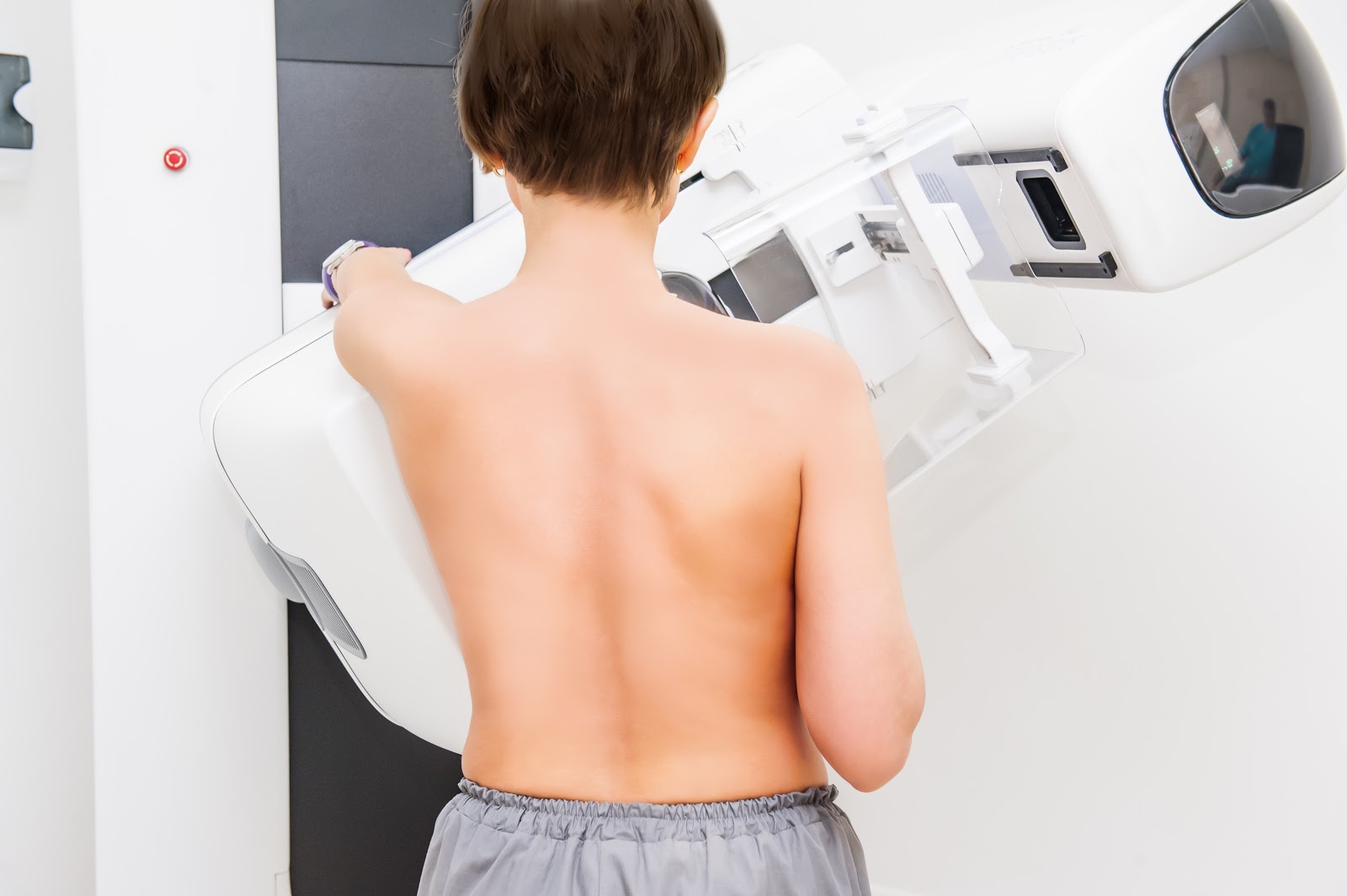 Patient standing in front of an x-ray for a diagnostic mammogram
